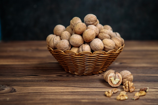 Een mand vol walnoten op een houten achtergrond