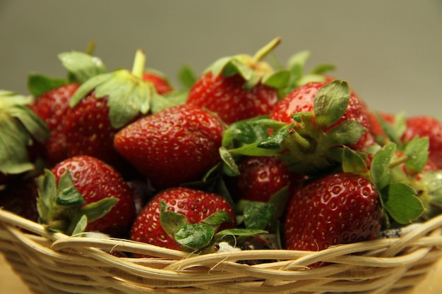 Foto een mandje aardbeien op een houten gesneden plank op een witte achtergrond