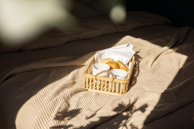 Foto een mandje brood en een kop koffie op een bed