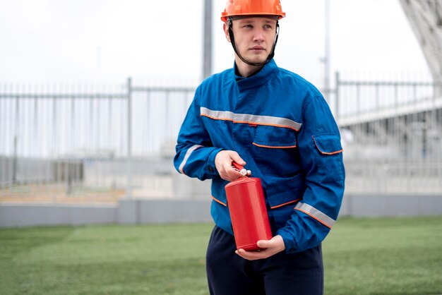 Een mannelijke arbeider in blauw uniform met oranje verkeerskegels op de snelweg