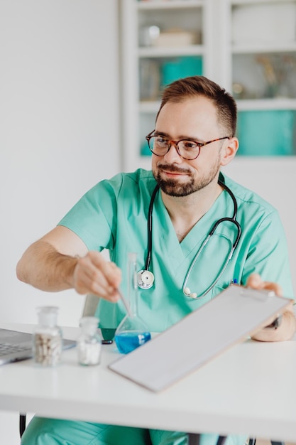 Een mannelijke arts zit tegenover een bureau van de patiënt en bespreekt medicijnen