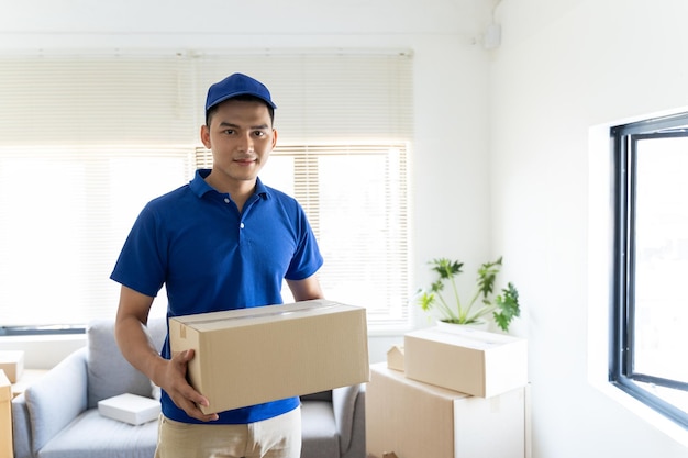 Een mannelijke bezorger in een blauw shirt en hoed vervoert goederen om klanten naar hun bestemming te brengen
