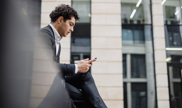 Een mannelijke ondernemer gebruikt een telefoon gaat naar zijn werk in een pak een succesvolle ondernemer