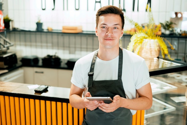 Een mannelijke werknemer van het restaurant werkt in zijn café Het favoriete bedrijf van een jonge zakenman