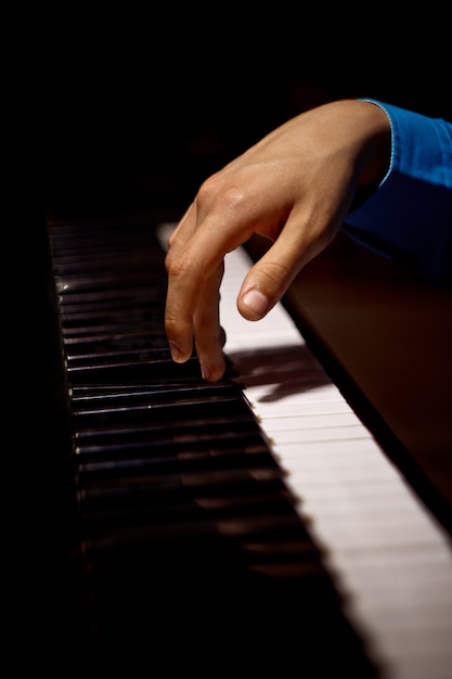 Een mannenhand op de piano.