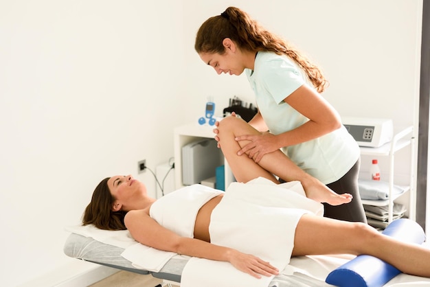 Een masseuse die een jonge vrouw masseert.