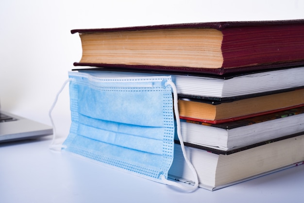 Een medisch of chirurgisch masker op een stapel boeken