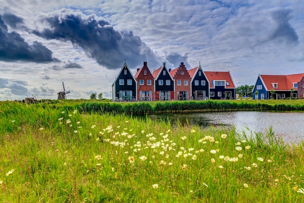 Foto een meer en huizen tegen een bewolkte hemel.