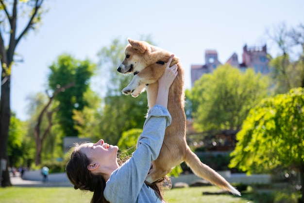 Een meisje dat een hond boven haar hoofd houdt