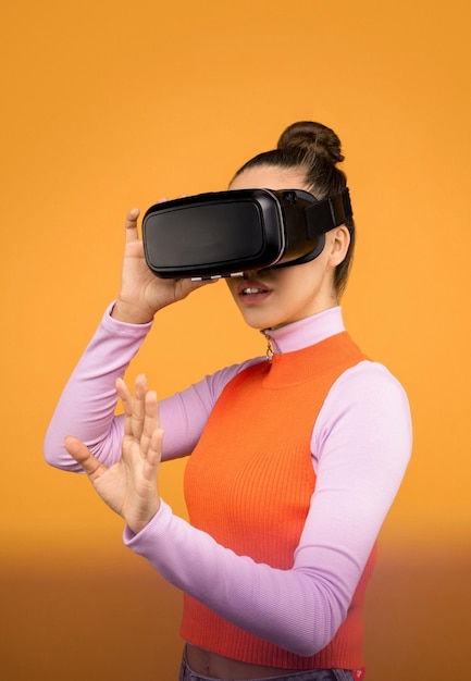 een meisje dat een virtual reality-bril draagt en interactie heeft met een vr ornge-achtergrond