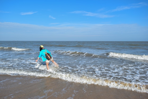 Een meisje dat water speelt bij de zee