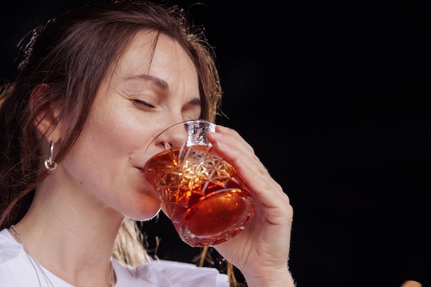 Een meisje drinkt een negronicocktail op het terras van een modern restaurant