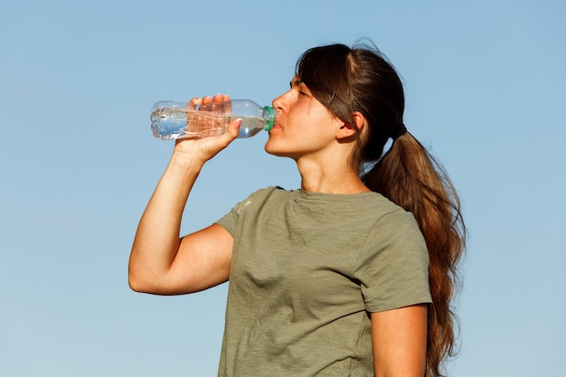 Een meisje drinkt water na het sporten, een gezonde actieve levensstijl