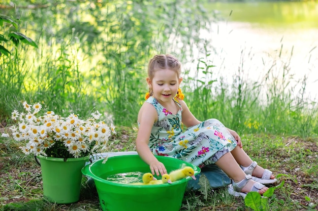 Een meisje en een eendje in de zomer buiten Gute baby's Geluk