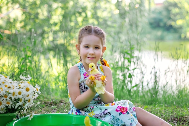 Een meisje en een eendje in de zomer buiten Gute baby's Geluk