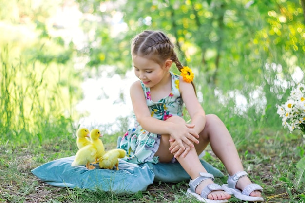 Een meisje en een eendje in de zomer buiten Gute baby's Geluk