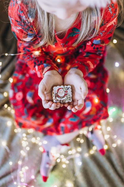 Een meisje houdt kerstkoekjes in haar handen