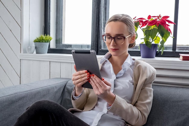 Een meisje in brillen werken met tablet pc.