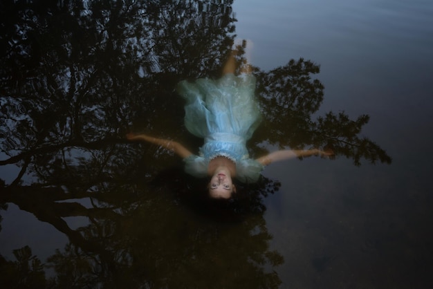 Foto een meisje in een blauwe jurk onder het water zelfmoord van een vrouw op het meer