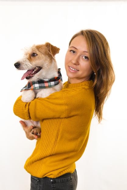 Een meisje in een geel jasje houdt een Jack Russell Terrier-puppy in een bandana-sjaal. Isoleren op witte achtergrond