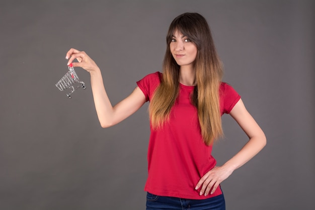 Een meisje in een rood T-shirt met een winkelwagentje