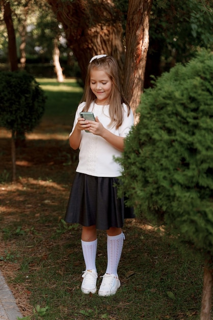 een meisje in een schooluniform loopt in het park