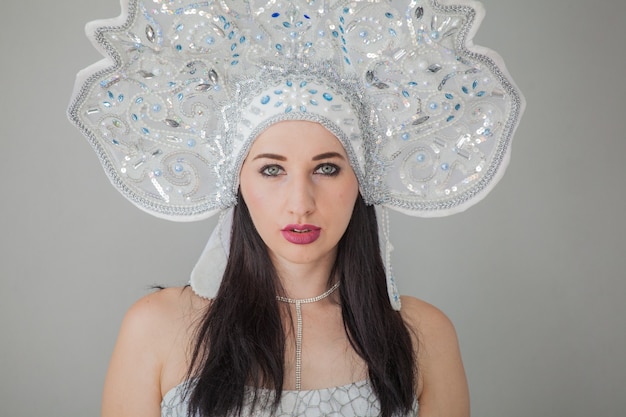 Een meisje in een sexy nieuwjaarskostuum van de Snow Maiden In de Russische kokoshnik