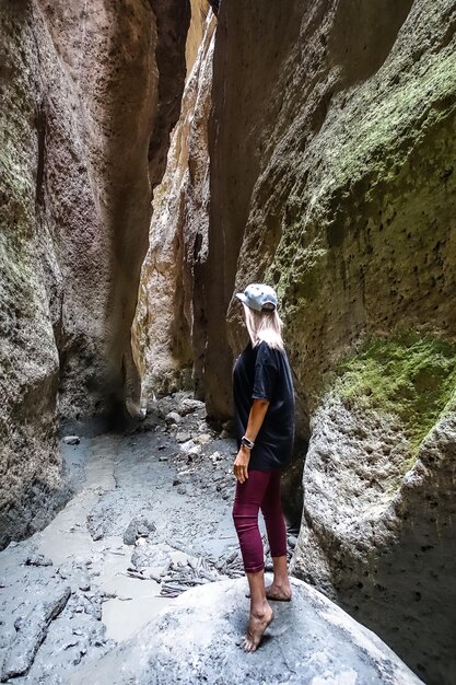 Een meisje in een smalle bergkloof Karadakh met zonlicht in Dagestan, Rusland juni 2021