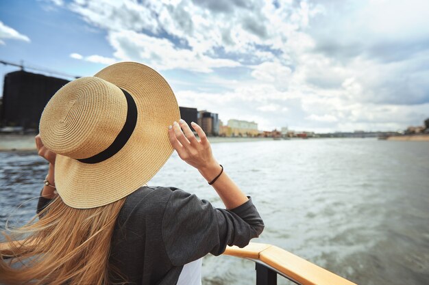 Een meisje in een strooien hoed op de boeg van het jacht gestrekt op een zonnige zomerdag