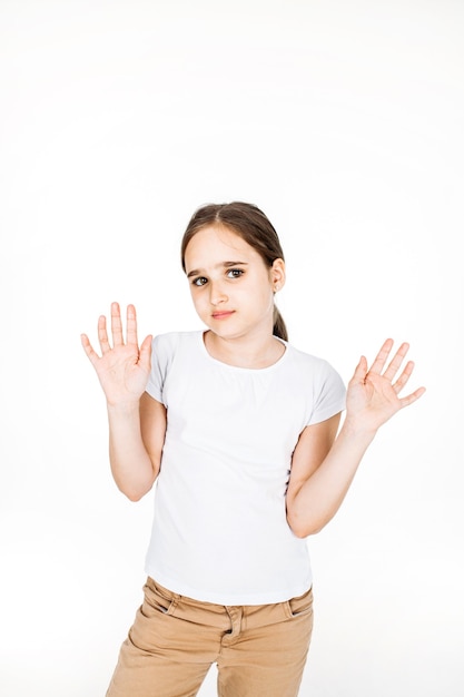 Een meisje in een wit t-shirt, broek met lang haar op een witte achtergrond, studio, tiener