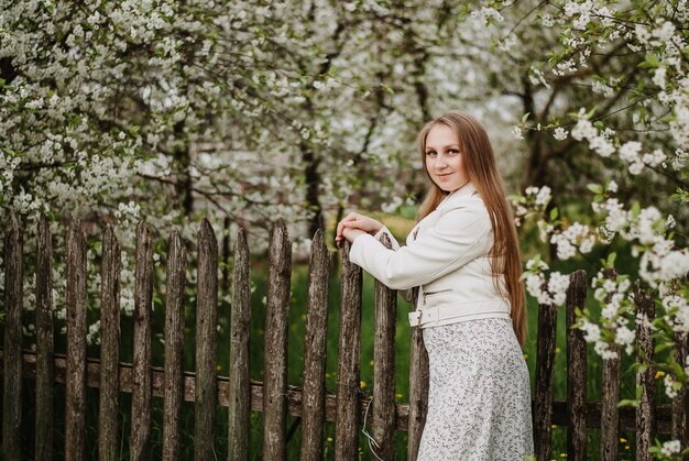 een meisje in het wit in een bloeiende tuin kersenbloesems een meisje met lang haar jong meisje