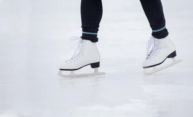 Een meisje in zwarte broek schaatst overdag op het ijs van het stadion