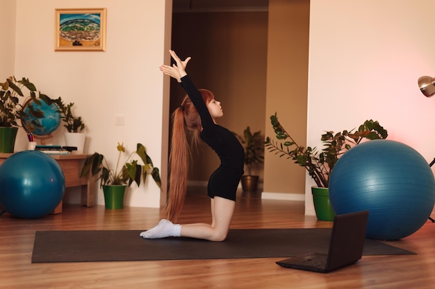 Foto een meisje in zwarte panty doet gymnastiek het meisje thuis is bezig met gymnastiek