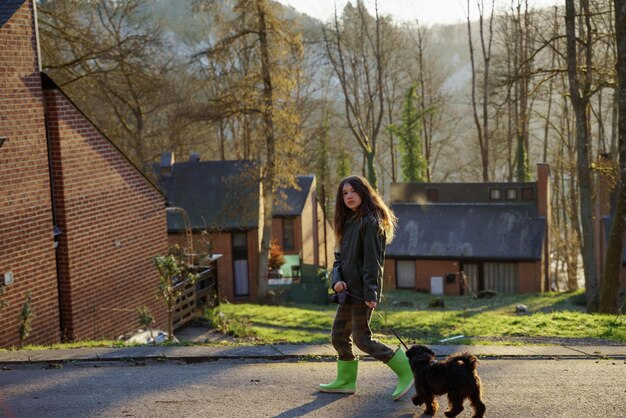 Een meisje loopt met een hond op de weg.