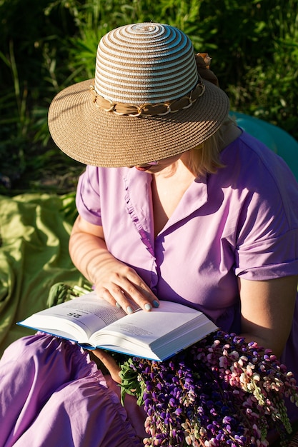 een meisje met boek in een bloeiend veld in de zon bij zonsondergang