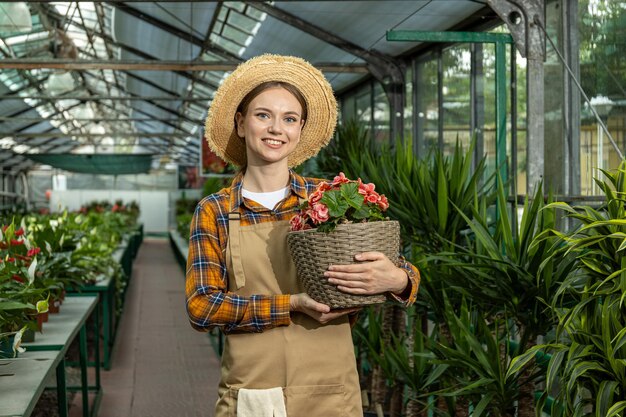 Een meisje met een kamerplant in een kas.