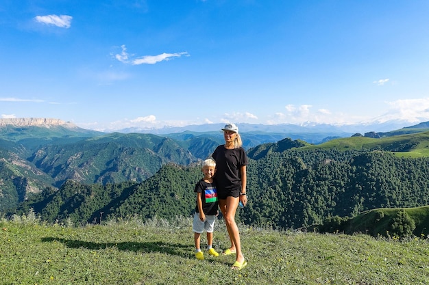 Een meisje met een kind op de achtergrond van het Kaukasusgebergte in de buurt van het gebied van JilaSu KabardinoBalkarië