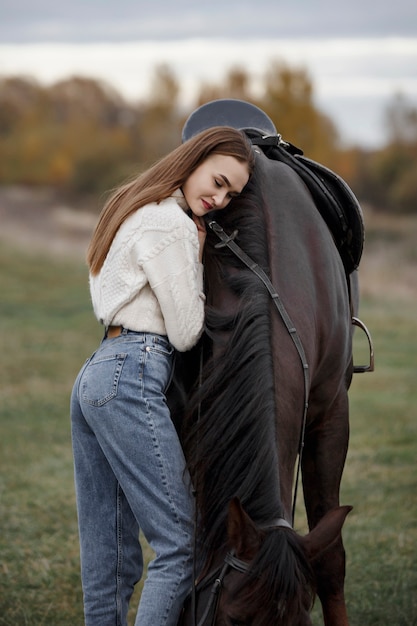 Foto een meisje met een paard in de natuur, een herfstwandeling met een dier