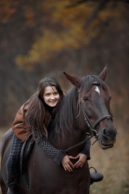 Een meisje met een paard in de natuur, een herfstwandeling met een dier