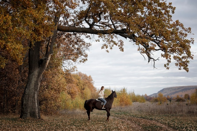 Een meisje met een paard in de natuur, een herfstwandeling met een dier