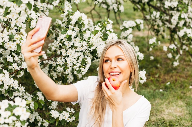 Foto een meisje met een telefoon in haar hand maakt foto's van zichzelf, selfies