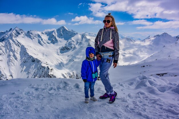 Foto een meisje met een zilver op de achtergrond van bergen in de winter en een besneeuwde top the kaukasus mountains elbrus 2019