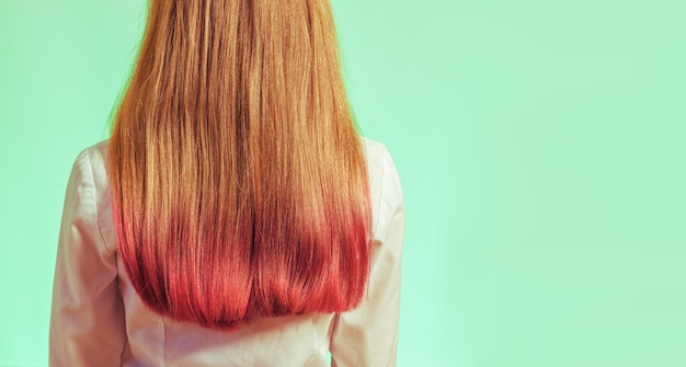 Een meisje met gedeeltelijk gekleurd haar in roze op een lichtgroene achtergrond