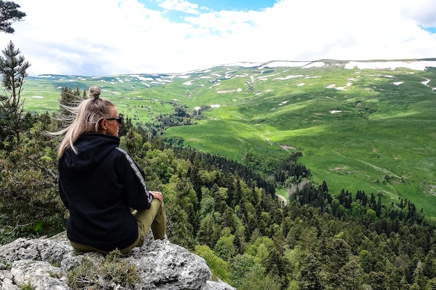 Een meisje op de achtergrond van alpenweiden van het LagoNaki-plateau in Adygea Rusland 2021