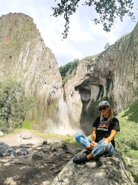 Een meisje op de achtergrond van de KarakayaSu-waterval op het grondgebied van KabardinoBalkarië