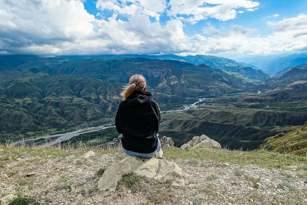 Een meisje op de achtergrond van een adembenemend uitzicht op de bergen in Dagestan Kaukasus Rusland 2021