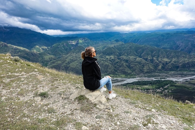 Een meisje op de achtergrond van een adembenemend uitzicht op de bergen in Dagestan Kaukasus Rusland 2021