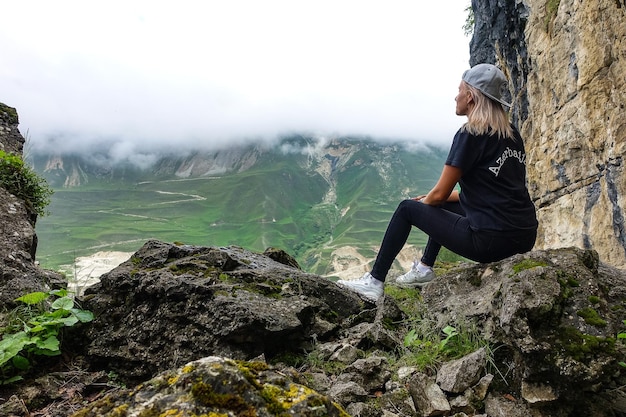 Een meisje op de achtergrond van een berglandschap in de wolken Stenen kom in Dagestan, Rusland