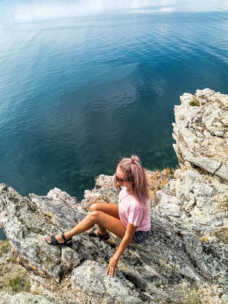 Een meisje op de achtergrond van een uitzicht op het Baikalmeer bij de Shamanka-rots Irkoetsk-regio Rusland