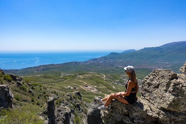 Een meisje op de achtergrond van het plateau van de Krim-bergen en de Zwarte Zee vanaf de top van Demerji Russia